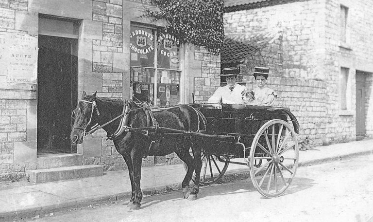 An early picture from about 1907 of the Hodder family in their pony and trap outside the newsagent. Cadbury's Chocolate is advertised on the shop window. The pony and trap was used to collect newpapers from Hallatrow Station. The pony and trap were kept in Revival, to the right of where Canine Craze is now.