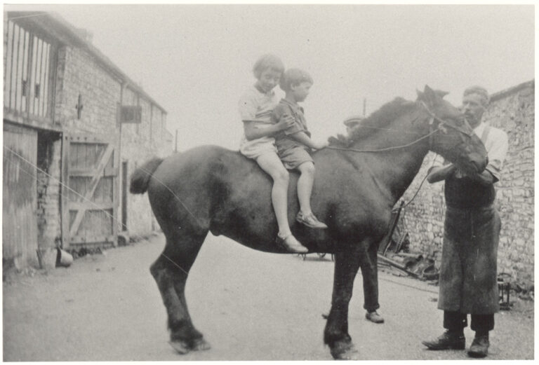 The horse, with two of his children, Rhona and Jake, is being held by Ernest Moxham outside the Forge in Church Lane.